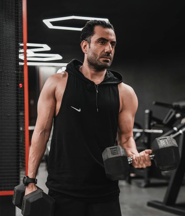 Man performing a controlled strength exercise in a modern, dark gym setting.