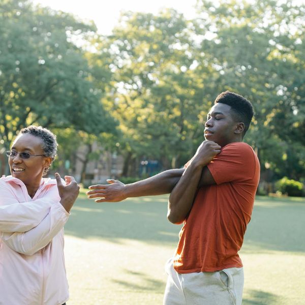 Silhouette of a man stretching at sunrise, symbolizing energy and vitality.